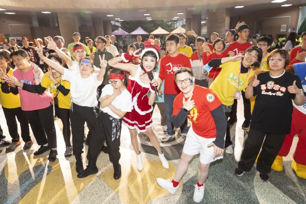 圖／藝人唐玲和30位頭戴狀元帽的喜樂家族成員，一起歡樂共跳潔牙舞。（松山社區大學 提供）