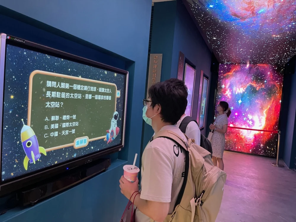 參觀民眾於「星空走廊」中央參與「太空天文大考驗」,在輕鬆問答中加深對天文與太空知識的理解。