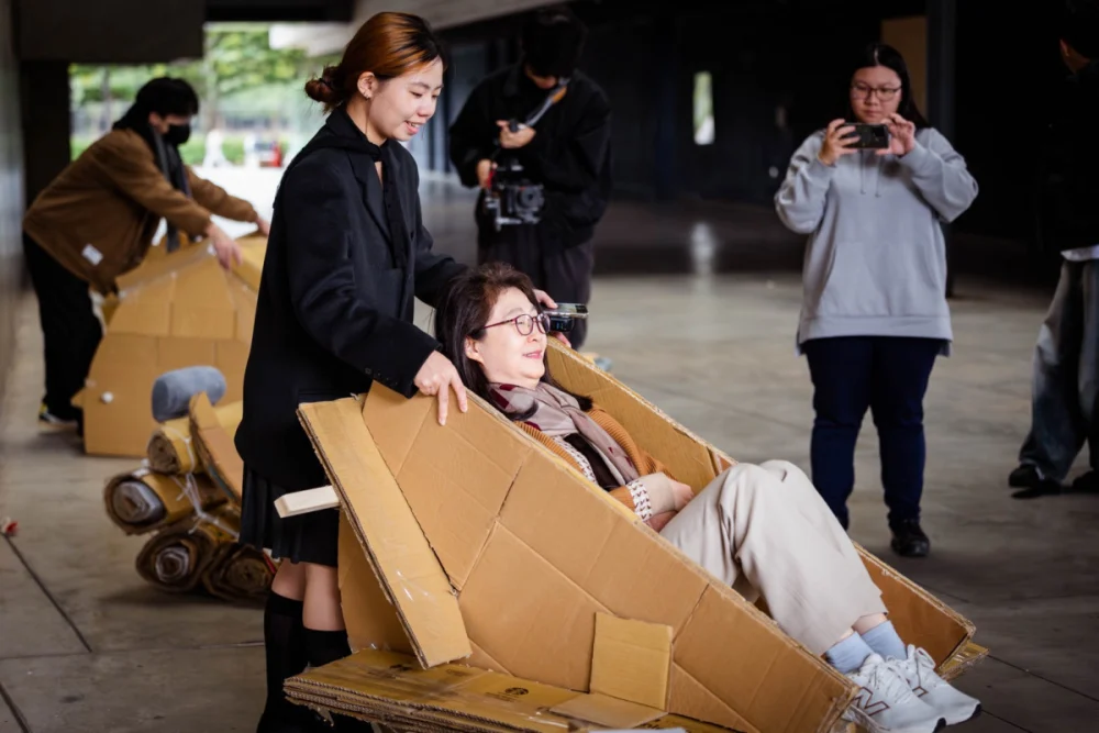 元智大學盧秋玲副校長體驗學生利用紙箱所製作的搖椅