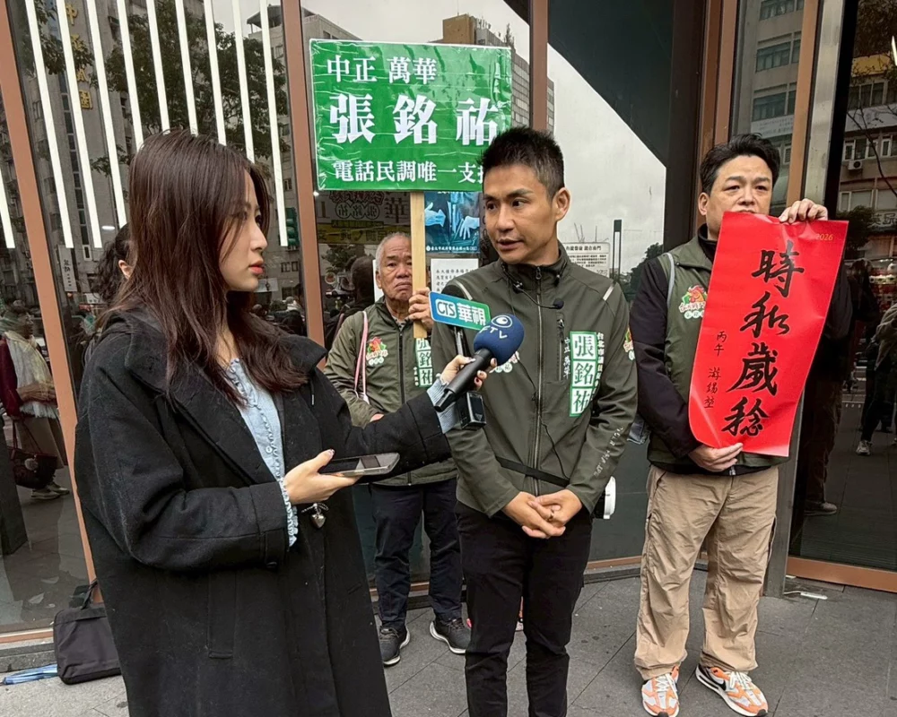 圖／張銘祐發送前立法院長游錫堃題字的「時和歲稔」春聯，向南門市場的攤商與往來鄉親拜早年。（張銘祐提供）