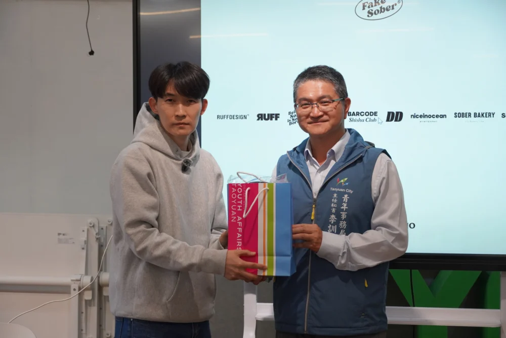 桃園市政府青年事務局李訓智主任秘書(右)贈與羅伊創始人禮品。