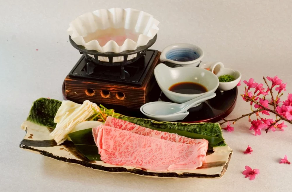 圖／最令人期待的亮點，莫過於融合了南非活鮑與頂級肉品的「A5黑毛和牛櫻花鍋」。A5和牛在熱騰騰的滾湯中輕涮數秒，肉片瞬間化為銷魂的脂香，入口即化。（莞固和食 提供）