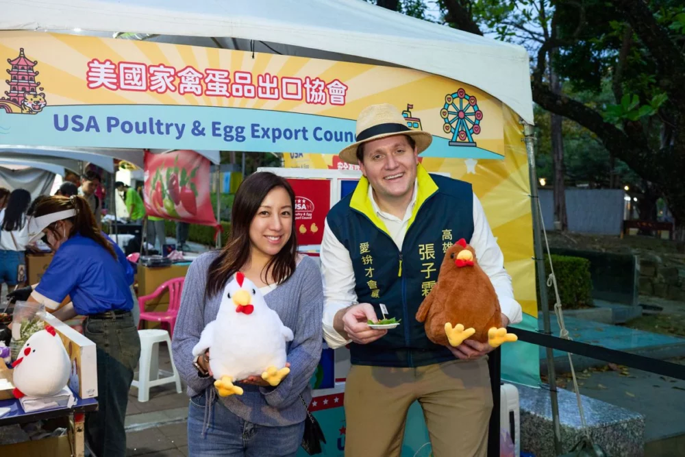 圖／美國在台協會（AIT）高雄分處處長張子霖（右）與美國家禽蛋品出口協會總監江嘉詠（左）與民眾同樂，參與現場互動小遊戲、品嚐愛心雞肉小點，感受活動熱鬧氛圍。（美國家禽蛋品出口協會 提供）