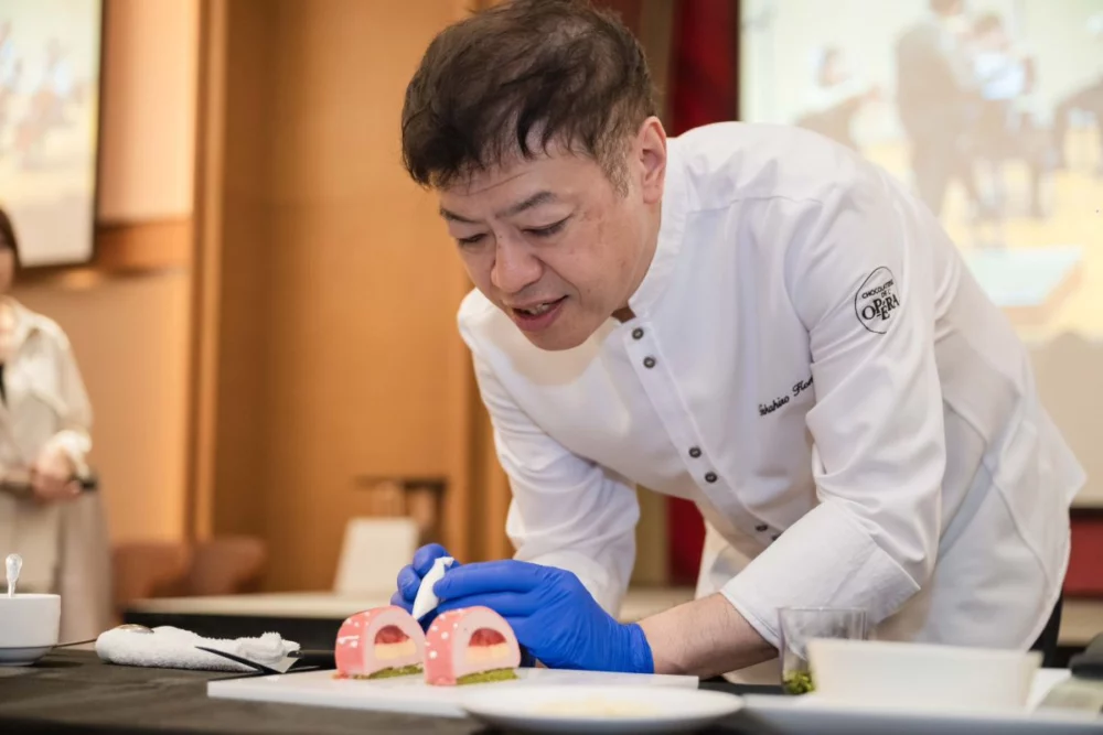 圖／Suzette主廚駒居崇宏，於《可可樂章》發表會現場親自示範盤式甜點裝飾工藝，展現世界級甜點職人的細膩技法與美學底蘊。（18度C巧克力工房提供）
