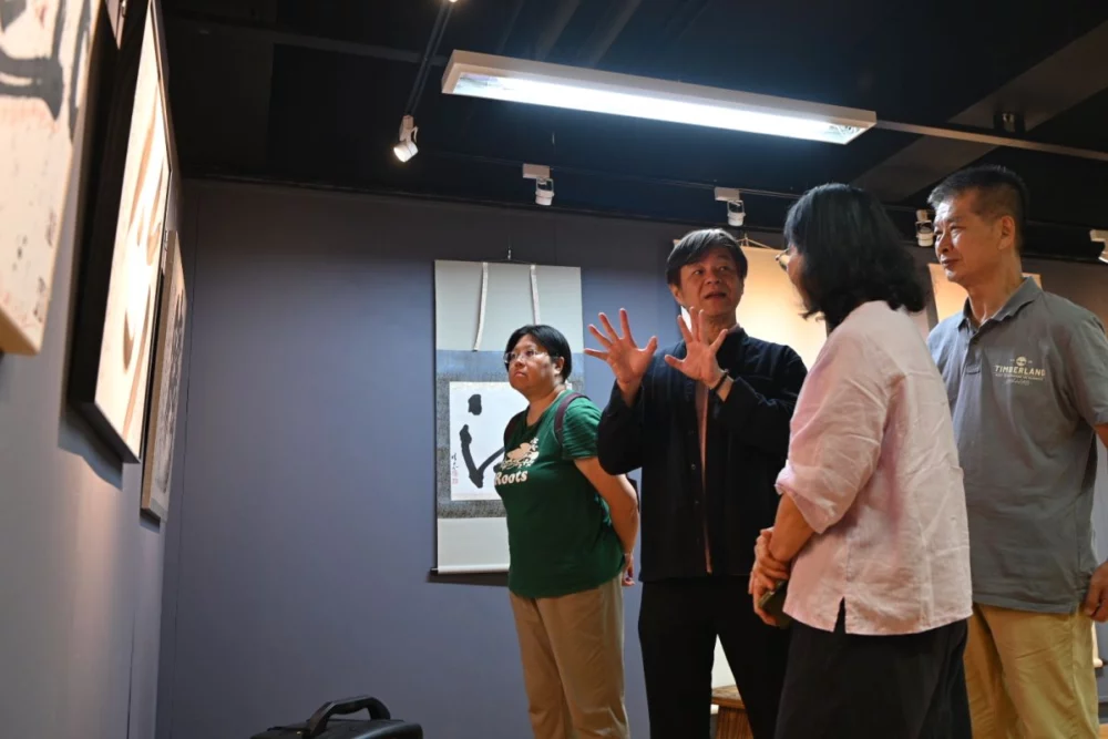 圖／策展人華梵大學人文與藝術學院黃智陽院長（左二）向參觀者導覽作品