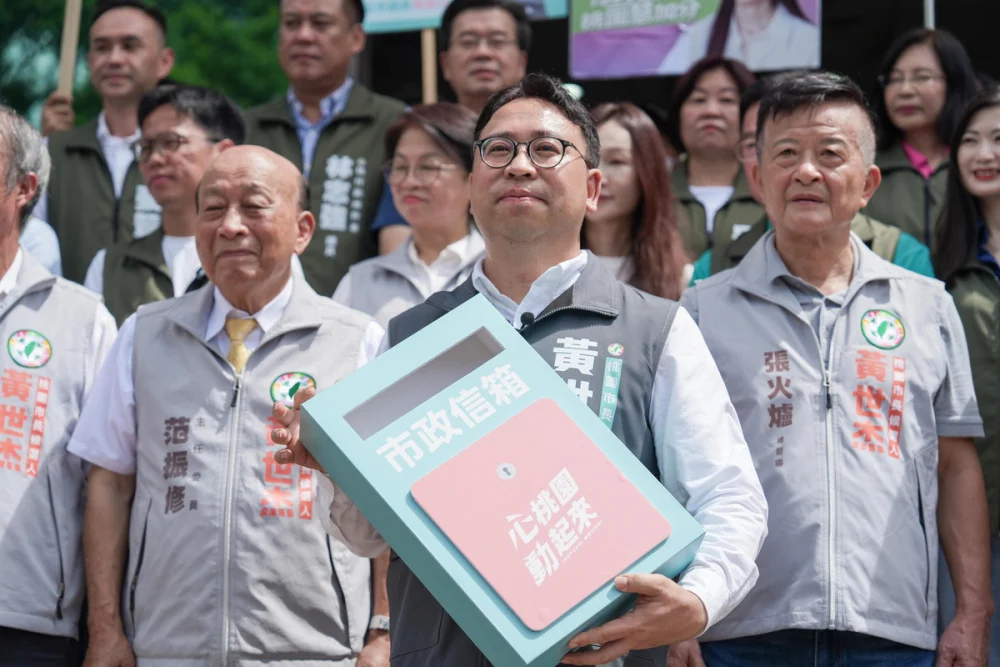 民進黨桃園市長參選人黃世杰手捧「市政信箱」接受議員參選人投入「桃園13區願望清單」。


” style=”width:100%; height:auto; display: black;”/></p>
<figcaption id=
